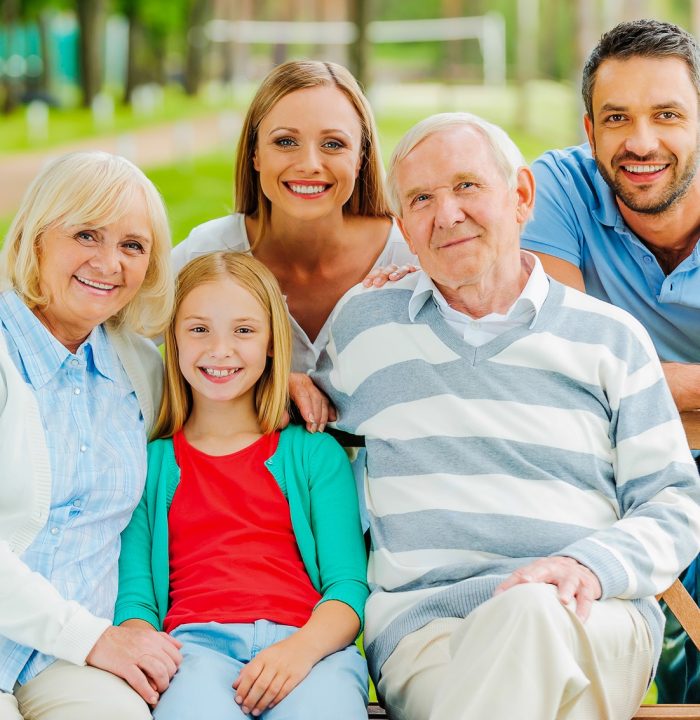 Happy family. Happy family of five people bonding to each other and smiling while sitting outdoors together